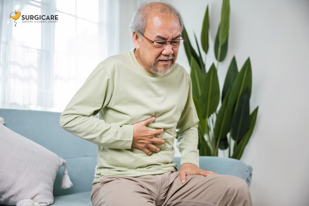 Senior Asian man clutching stomach